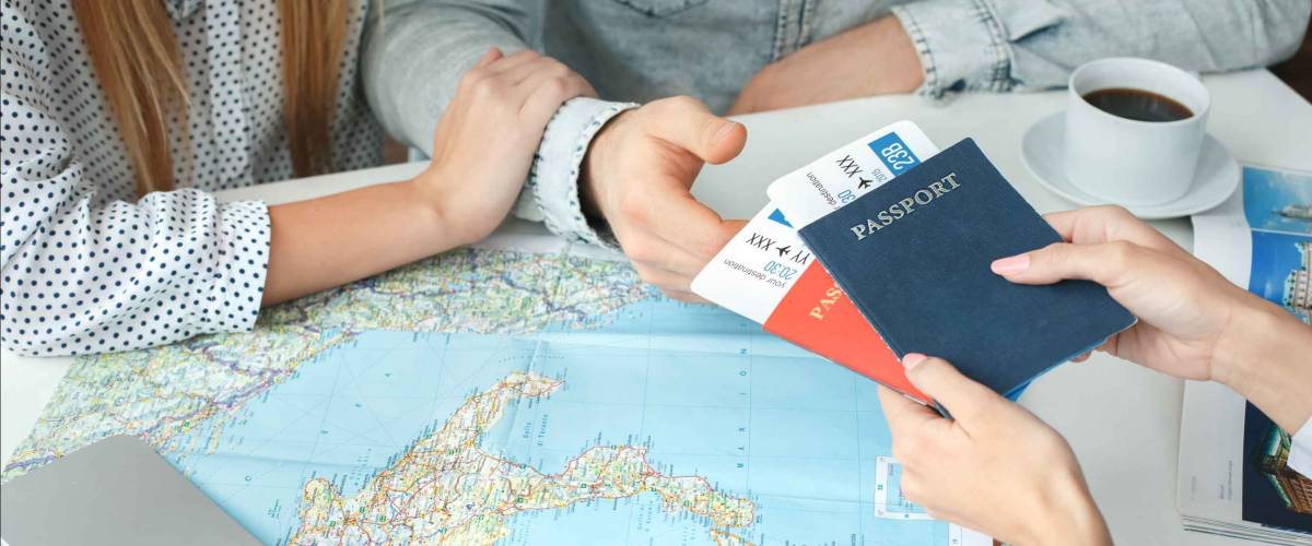 Young couple in a tour agency communication with a travel agent travelling concept passports and tickets