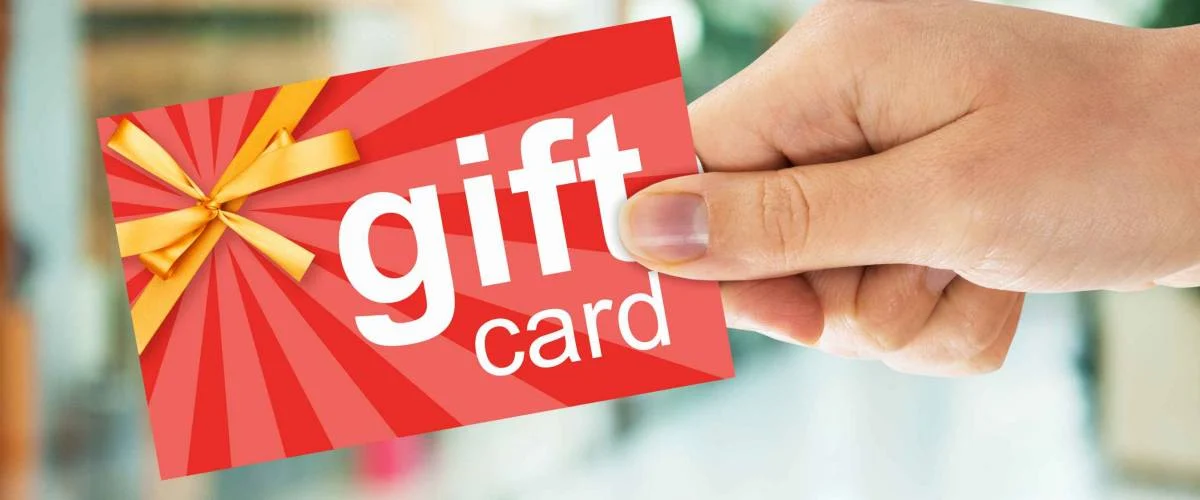 Cropped image of person's hand holding gift card