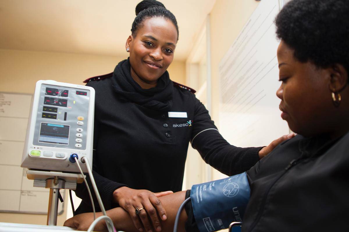 a woman taking the blood pressure of a patient