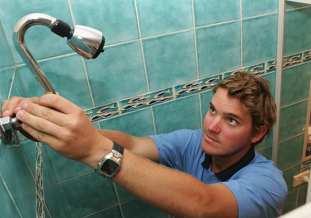 Guy fixing showerhead